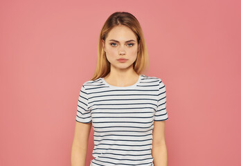 Obraz premium beautiful woman in a striped T-shirt fun hand gestures pink background