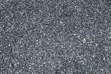 The pebbles were poured onto the ground and flattened to form a garden path, leaving a somewhat uneven texture.