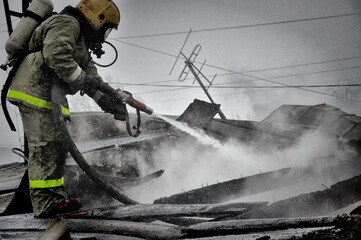 Firefighters extinguish a fire on the roof of a house on a frosty winter day