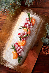 Festive Christmas meringue roll with cherries on table.