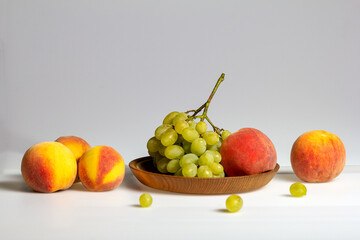 Fruits-grapes, peach, dogwood berries on a milky white background and gray background, close-up.