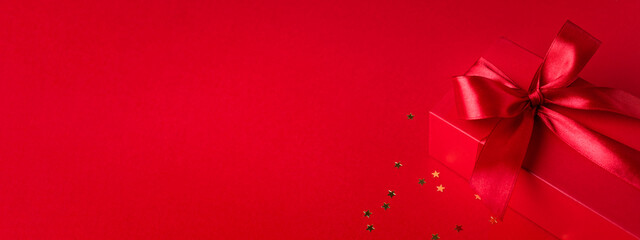 Banner with red gift box for Christmas or Valentine's day on red background .