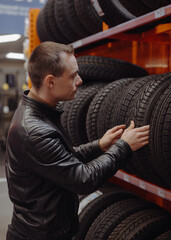 Obraz na płótnie Canvas Man chooses winter car tires in the auto shop