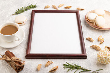 Brown wooden frame mockup with cup of coffee, almonds and macaroons on gray concrete background. side view