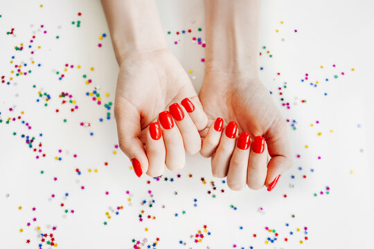 Manicured woman's nails with red nail polish.