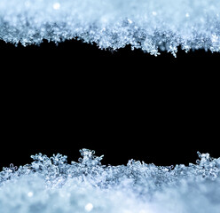 Natural snow texture with snowflakes close-up, isolated on black background with space for text in the center. Template for holiday gift cards. Macro texture of snow.