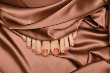 Female feet with bronze nail design. Glitter bronze nail polish pedicure with nail art. Woman feet...