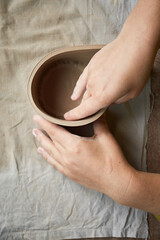 Female ceramist working in pottery studio. Ceramist's Hands Dirty Of Clay. Process of creating pottery. Master ceramist works in her studio