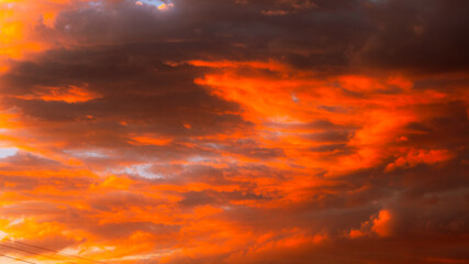 Fototapeta na wymiar Dramatic orange clouds at sunset. Cloudscape abstract background photo.