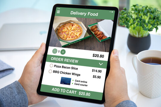 male hands hold computer tablet with food delivery application screen