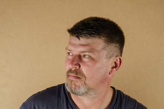 Portrait Of A 45 Year Old Man Looking Away. Adult Unshaven Male Indoors