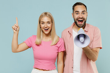 Young couple two friends family man woman in casual clothes hold scream in megaphone announces discounts sale Hurry up together isolated on pastel plain light blue color background studio portrait