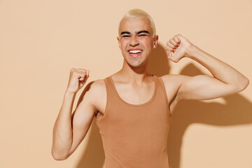 Young satisfied happy blond latin american hispanic gay man with make up in beige tank shirt do...
