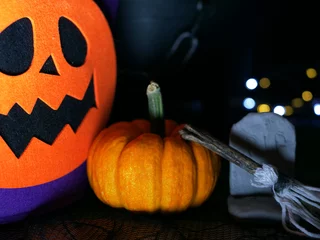 Foto op Plexiglas Halloween decorations with pumpkin and tombstone on dark background © Angela