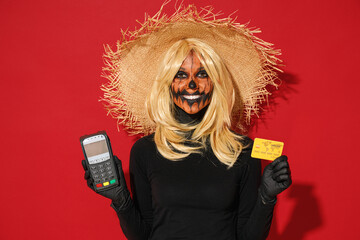 Young fun woman with Halloween makeup mask wears straw hat black scarecrow costume hold wireless...