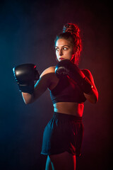 Sporty woman doing boxing exercises, making direct hit. Photo of young girl. Strength and...