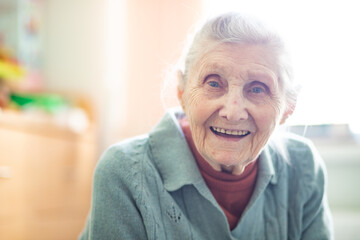 Portrait of a grandmother, an old woman sitting at home, 90 years old, old age, wrinkles on her face.
