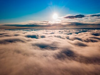 High flight over the fog in the mountains. Ukrainian Carpathians in the morning. Aerial drone view.