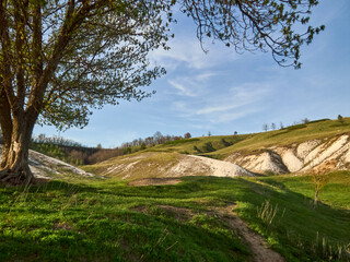 Obraz premium Chalk mountains, green grass and blue sky, spring landscape