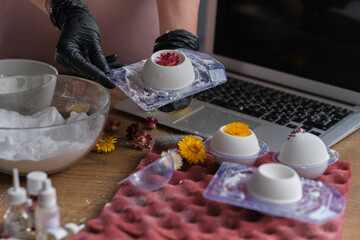 woman is taking an online lesson or watching a video on creating bath bombs. Online training, online classes. master creates handmade cosmetics