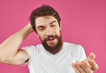 Obraz premium Man in a white t-shirt surprised look pink background