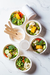 Vegan vegetable salad in paper take away bowls. Eco-friendly recyclable tableware, zero waste concept.