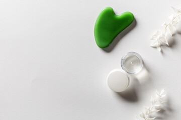 Gouache scrapes from green jade and moisturizing gel, floral decorated. Natural gem stone massager © yrabota