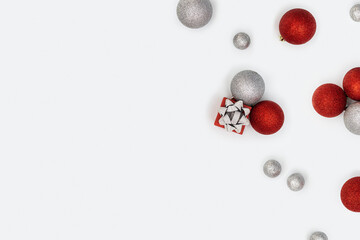 Christmas layout with shining red and silver Christmas balls and small gift box or present