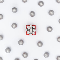 Christmas baubles decorations, silver colored balls and gift box with surprise New Year holiday pattern
