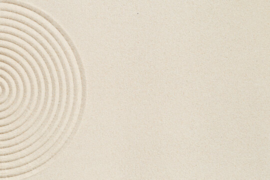 Lines drawing on sand, beautiful sandy texture. Spa background, concept for meditation and relaxation