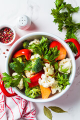 Vegetarian soup with broccoli, cauliflower, peppers and sweet potatoes in saucepan. Cooking healthy food concept.