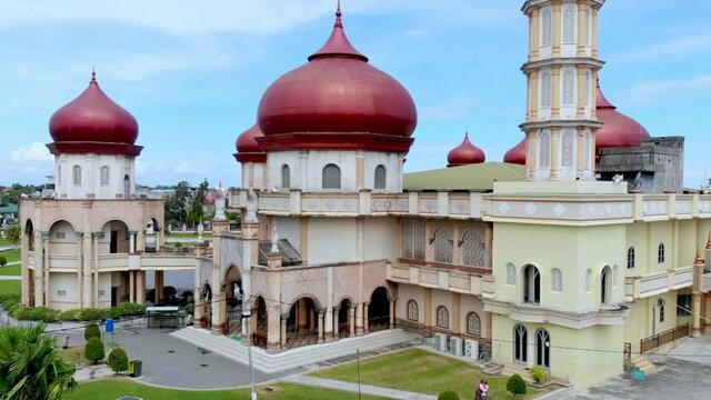 Aerial video of the Baitul Makmur Grand Mosque, West Aceh, looks at the front of the mosque with the drone moving upwards