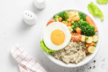 Savory oatmeal bowl, vegetables seeds and leafy greens. Space for text, top view.