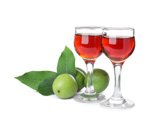 Delicious liqueur and green walnuts on white background