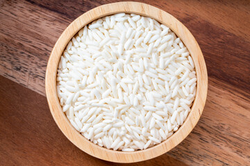 Rice grains in wooden bowl on wooden background, Jasmine rice grains in wooden bowl on wooden background.
