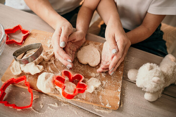 close-up mom and daughter made a heart out of dough