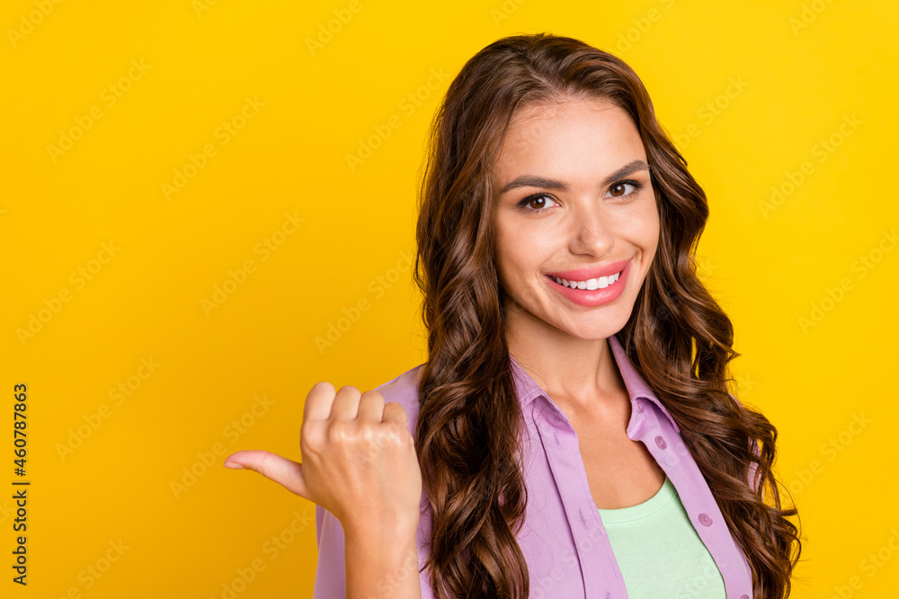 Poster Portrait of attractive cheerful wavy-haired girl demonstrating copy space ad new isolated over bright yellow color background