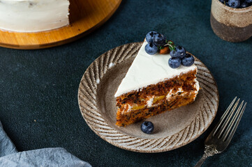 piece of carrot cake with walnuts and blueberry on dark wood background. Local food. Traditional american cake. Cake for thanksgiving day. Christmas cake.