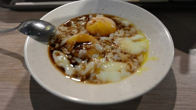 Two half boiled eggs served with soya sauce.