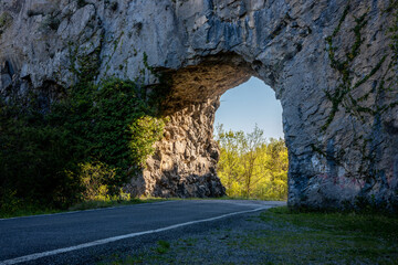 View of a road that crosses the stone arches in the form of a tunnel in Huesca