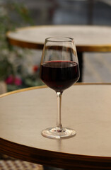 A glass of red wine on the summer terrace of a Parisian restaurant
