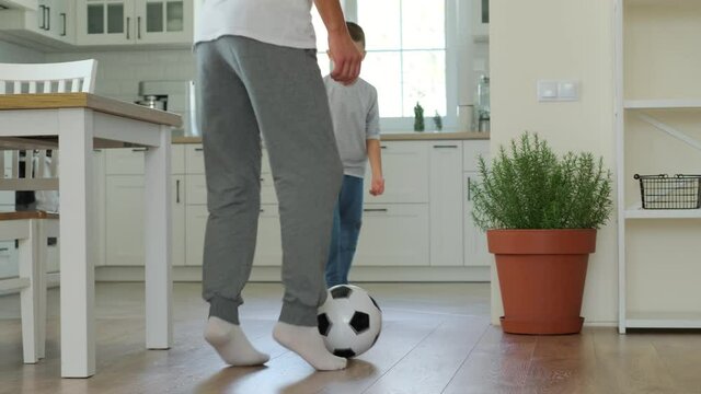 Happy father and son playing football at home