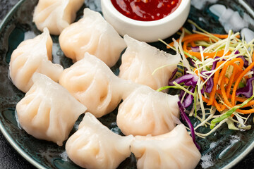 Traditional Asian Prawn or shrimp dumplings hakau, ha kauw or har gow. Served with cabbage, carrot salad and soy and sweet chilli sauce