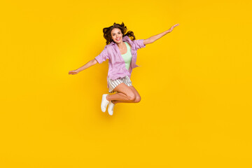 Fototapeta na wymiar Full body photo of positive happy young woman jump up enjoy hands plane wings isolated on yellow color background