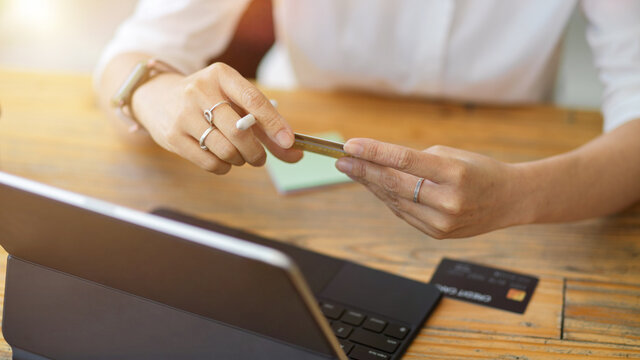 Woman sit at working desk with tablet and credit card. online payment