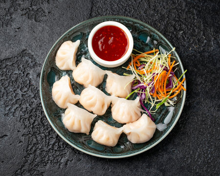 Traditional Asian Prawn or shrimp dumplings hakau, ha kauw or har gow. Served with cabbage, carrot salad and soy and sweet chilli sauce