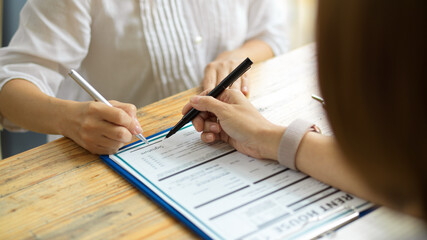 A new renter signing her signature on a home rental contract form