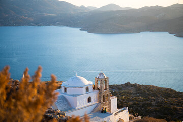 Fototapeta premium White Greek Church on the island at sunset in sunbeams