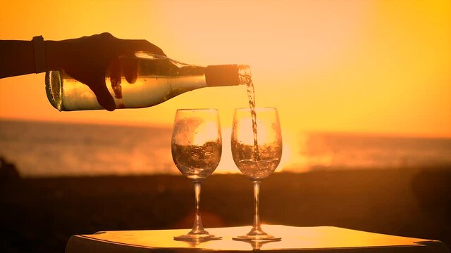 A glass of wine at sunset by the sea. Selective focus.