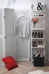 Dressing room with folding screen and decorative ladder. Contemporary interior design
